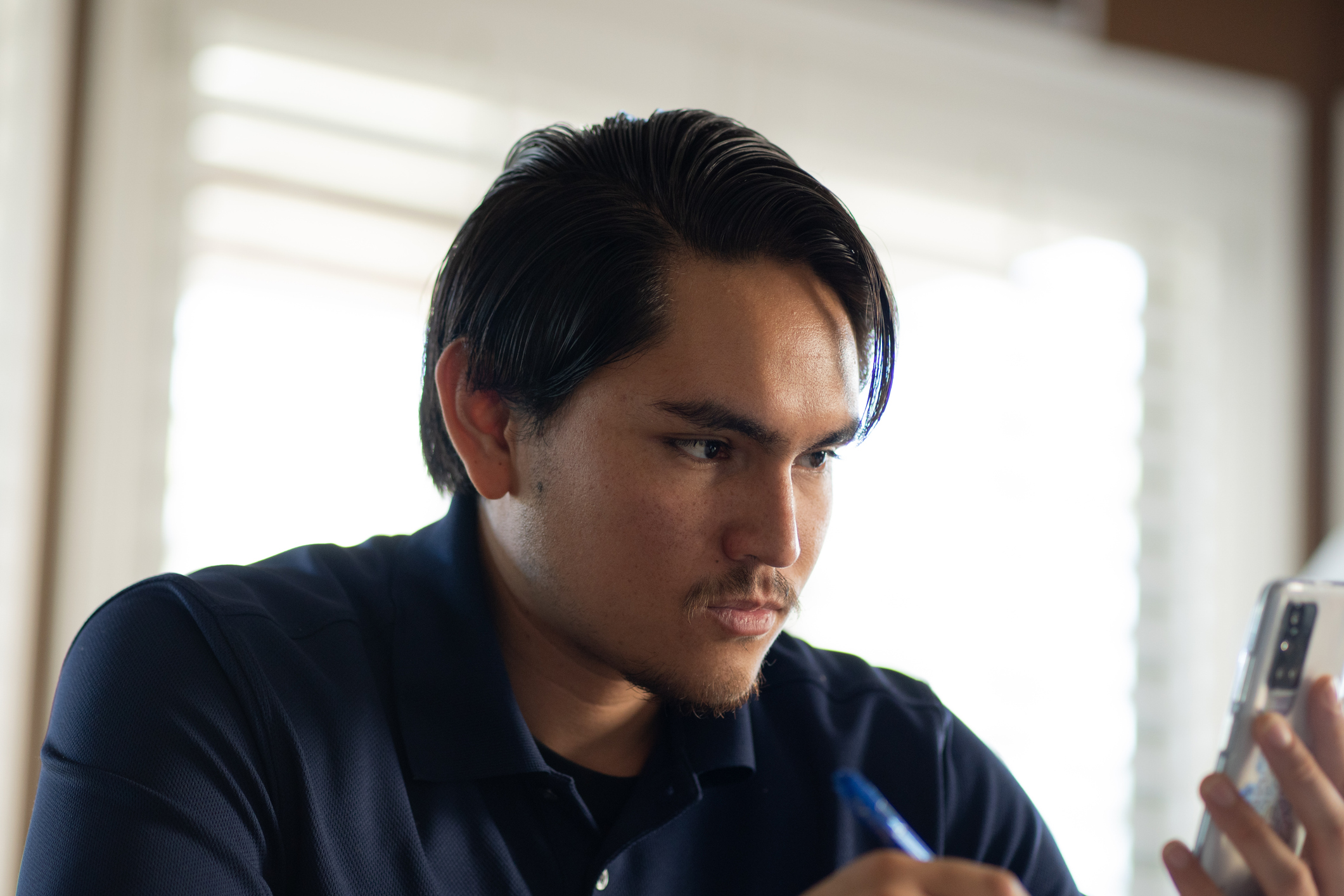 Man working from home using the phone and taking notes