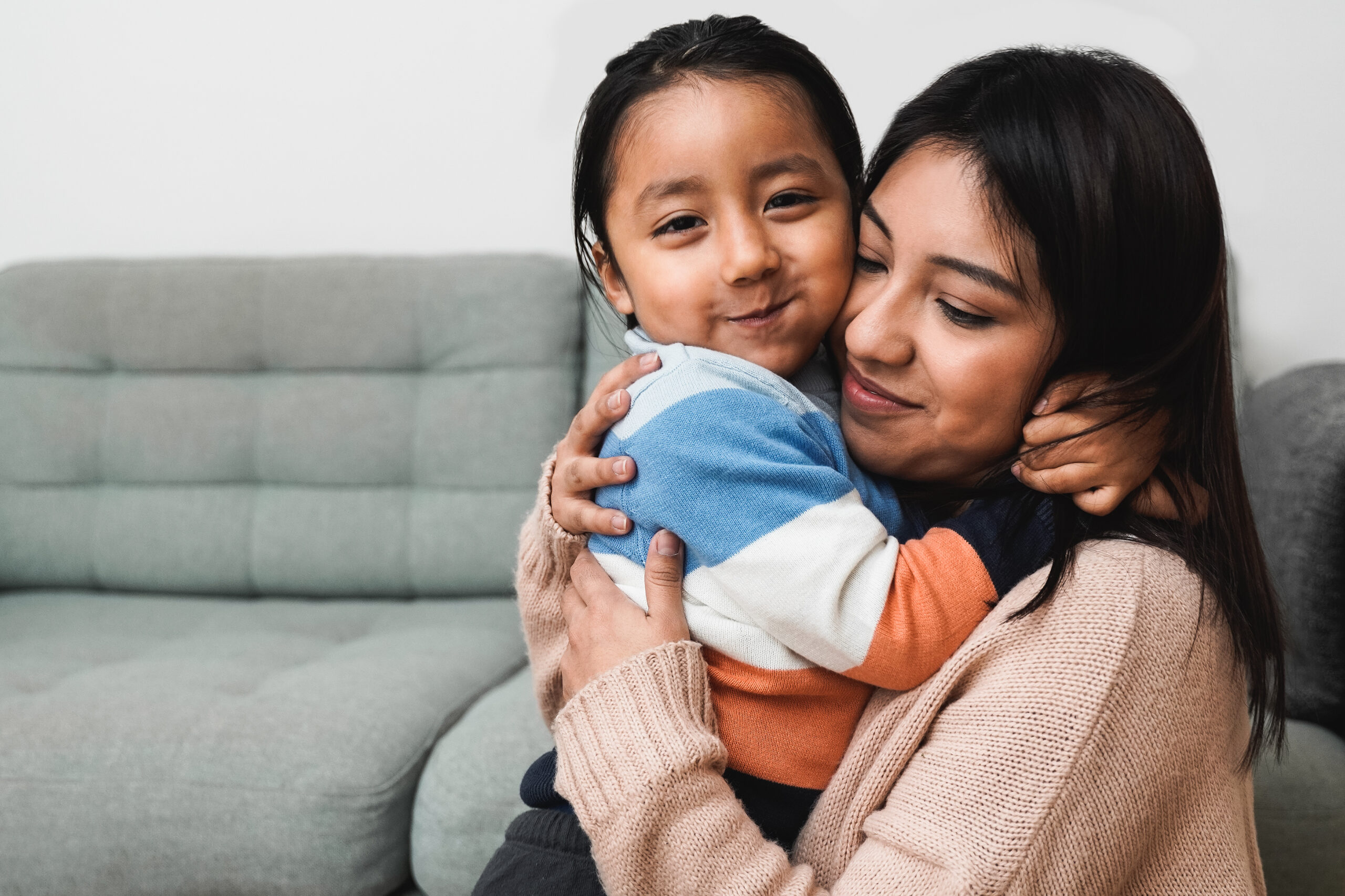 Happy Latin American mother and son hugging each other at home - Family love concept - Focus on child face